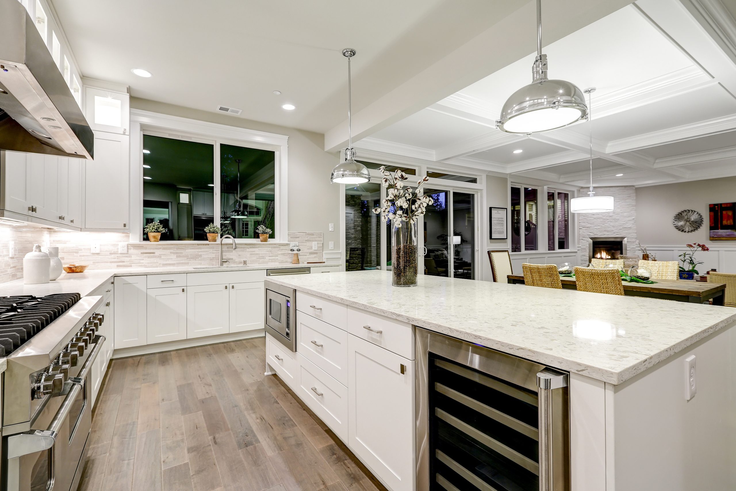 Large remodeled kitchen with white cabinets, large island and marble countertops. 